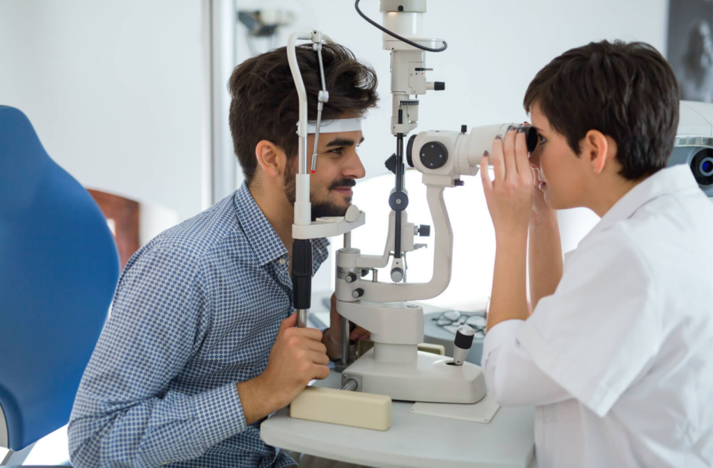 A man and his female optometrist perform an eye exam using a medical device to detect eye problems.