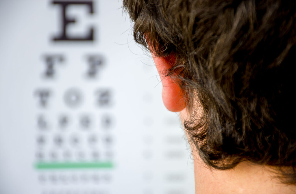 A young person looking at a blurry eye chart during an eye exam to represent high myopia.