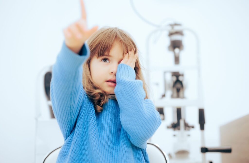 Child at an eye clinic covering one eye during vision therapy for convergence insufficiency.