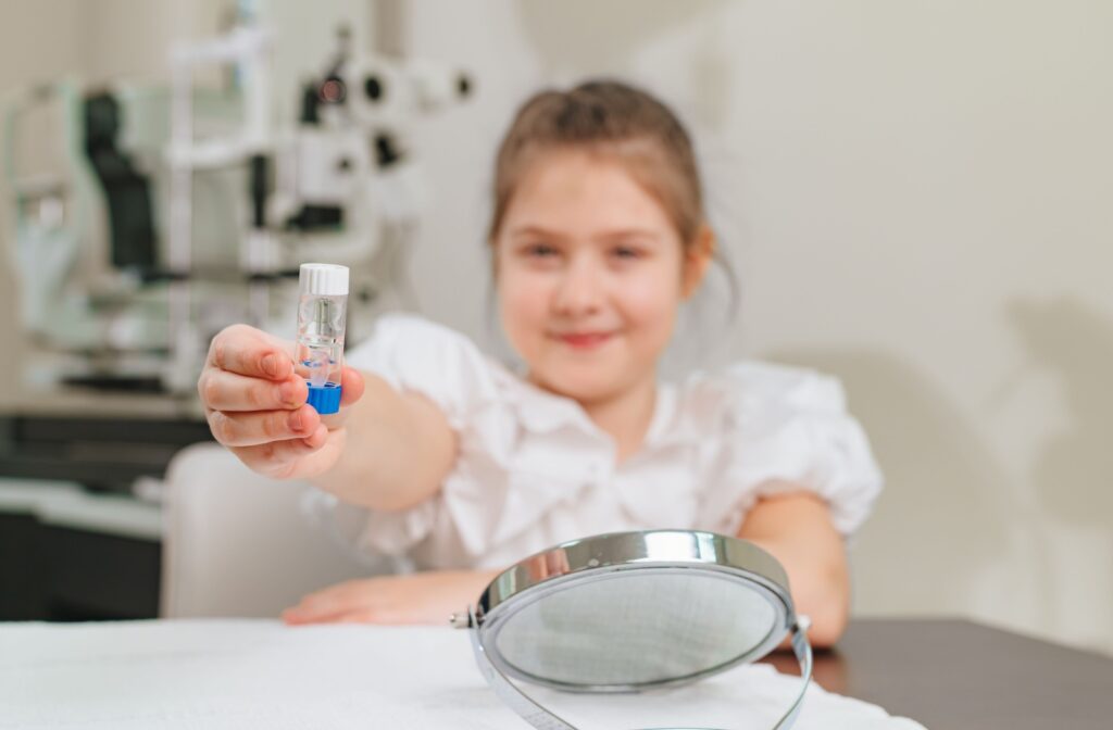 A young patient holding their ortho-k lens container during their contact lens fitting appointment.