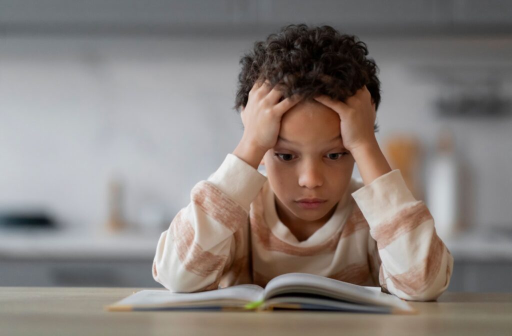 A young boy with a perplexed expression struggles to read.