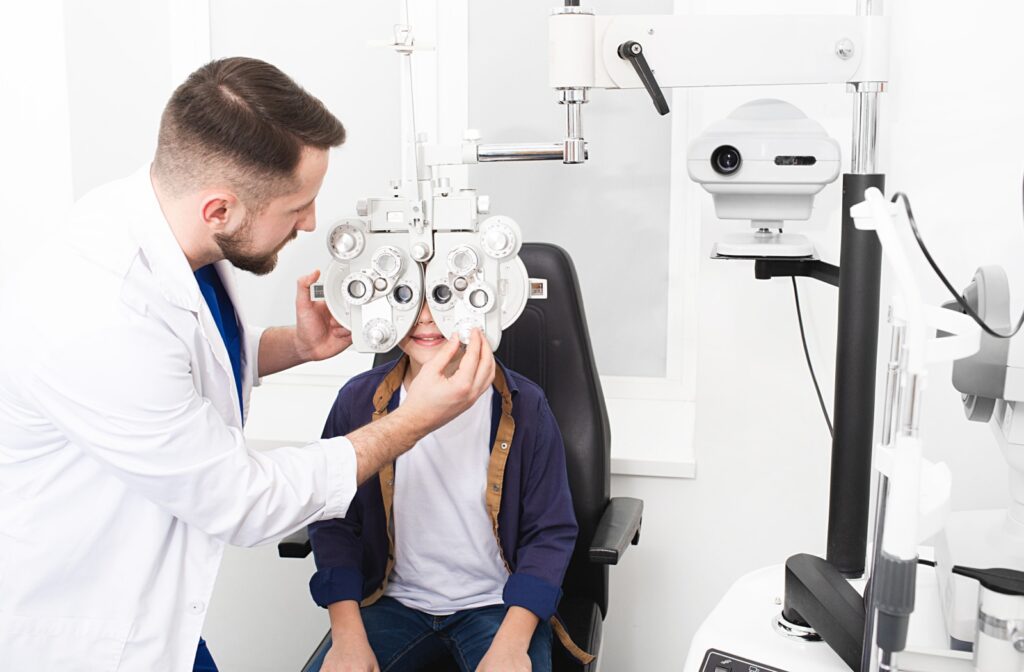 An eye doctor checks their young patient's eyes for refractive errors like myopia.